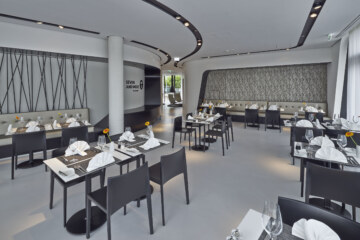 The Bavarian restaurant near Munich "Seven And More" with modern furnishings & laid tables.