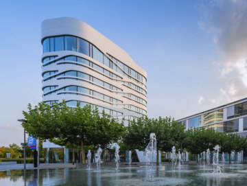 Außenansicht des Designhotels Campus at Home bei München mit Brunnen im Vordergrund.