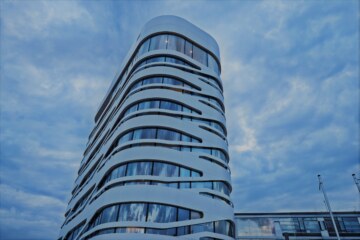 The building of the Design Hotel near Munich in front of a cloudy sky.