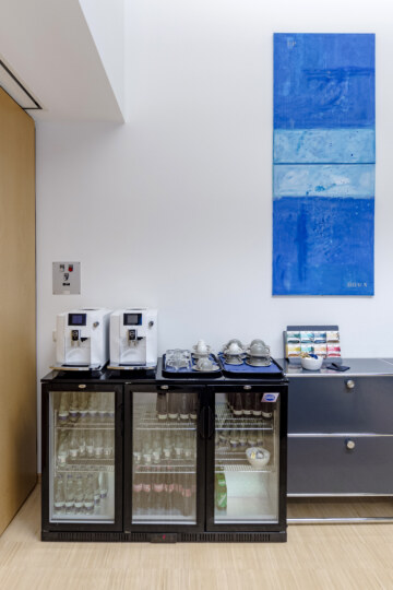 A refrigerator with beverages, a coffee machine, and tea in the conference hotel in Munich.
