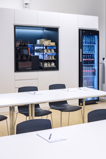 Conference room "Ellipse 2" in the conference hotel in Munich with a refrigerator and coffee machine.