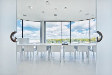 Konferenzraum in Design Hotel bei München mit länglichem Tisch und weißer Bestuhlung