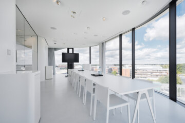 Konferenzraum in Design Hotel bei München mit länglichem Tisch und weißer Bestuhlung